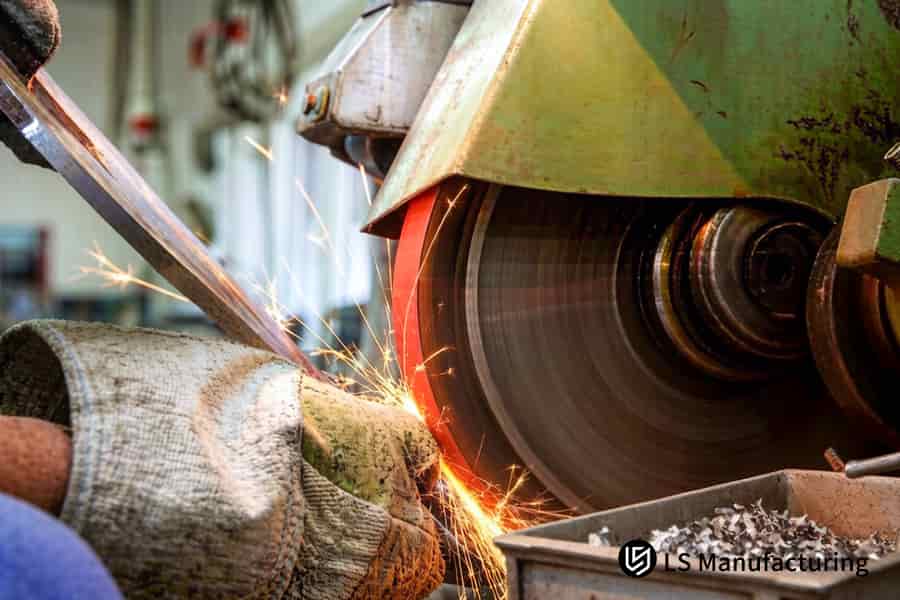 A grinder finishes the bevel edge on a stainless steel pipe for precision fit-up in pipe welding.