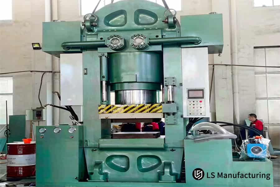 A hydraulic press forms a heavy-duty metal part for automotive chassis or structural frame fabrication.