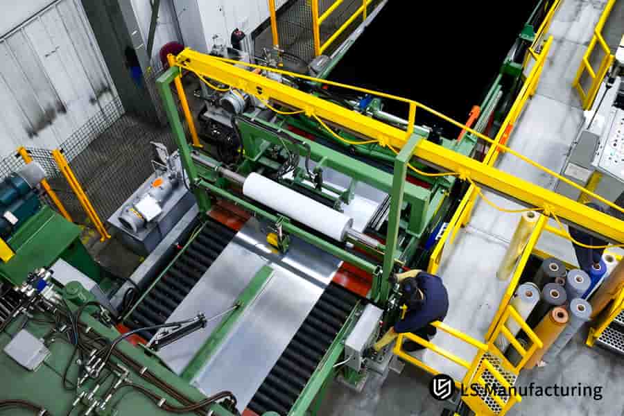 An operator monitors the blanking machine processing 5052 aluminum sheet for large scale electronic component manufacturing.