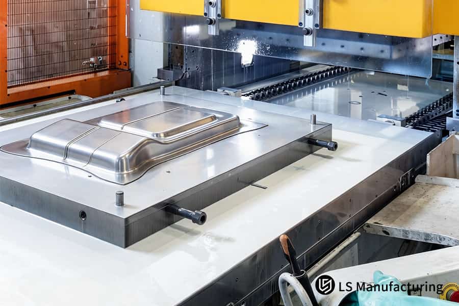 The hydraulic press forms a DC04 steel battery tray in a CNC guided blanking operation for automotive use.